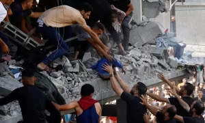 Người dân Palestine đưa trẻ nhỏ ra khỏi tòa nhà đổ nát vì đòn không kích Israel nhắm vào Khan Younis, phía nam Dải Gaza, hôm 24/10. Ảnh: Reuters